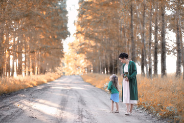 Fototapeta na wymiar Mother with daughter walking on a road