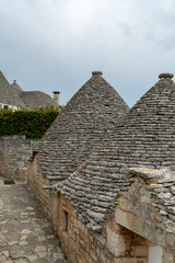 Unique small South Italia city Alberobello with antient stones conical houses trullo, tourist...