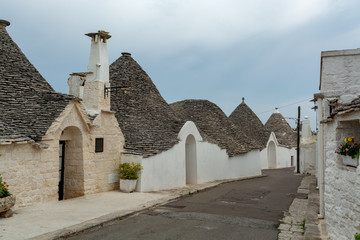 Unique small South Italia city Alberobello with antient stones conical houses trullo, tourist destination