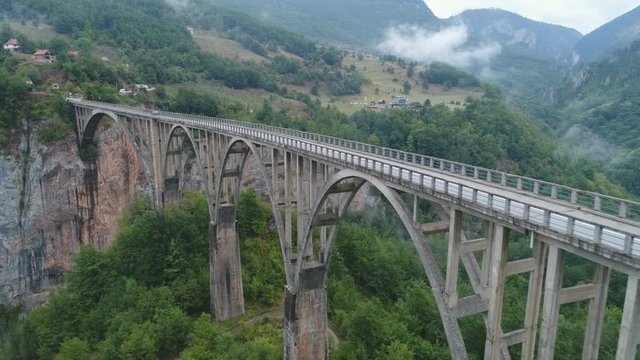 Tilting drone shot of long Durdevica bridge across the Tara river in Montenegro