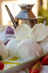Fresh soft Italian white cheese mozzarella buffalo, original from Campania, Paestrum and Foggia regions, South Italy, served with tomatoes and fresh basil © barmalini