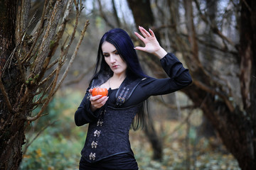 A woman in a witch suit in a forest