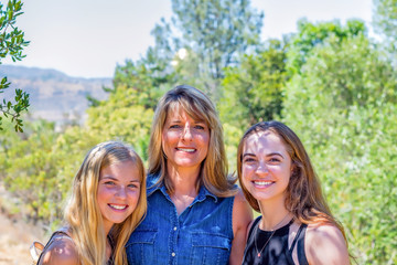 Mother and daughters on family walk in nature with natural light