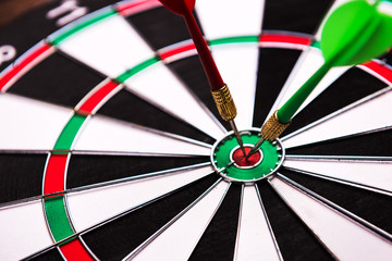 Darts hitting target. Two darts and target