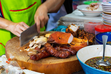 Trader are chopping steamed crispy pork and roasted red pork