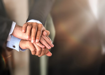 Close up of stacked hands of business people putting hands togethershowing unity and teamwork