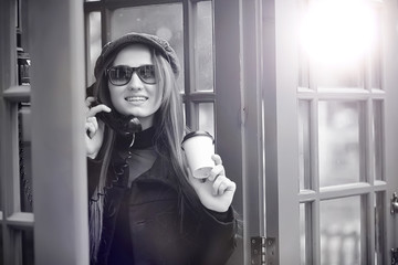 Beautiful young girl in a phone booth. The girl is talking on th