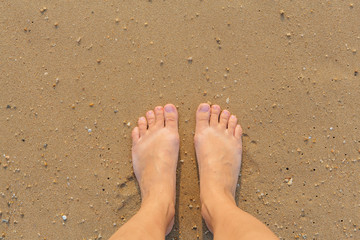 Bare female feet on the sea shore