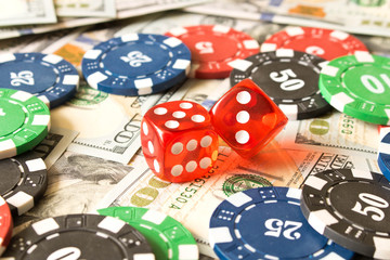 Dice and poker chips on the background of scattered 100 bills. Winning concept
