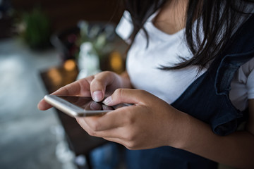 Young woman using and looking at smartphone with feeling happy