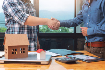 Real estate agent shaking hands with his client after sealing deal.