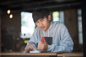 Hipster bearded man reading book in cafe..