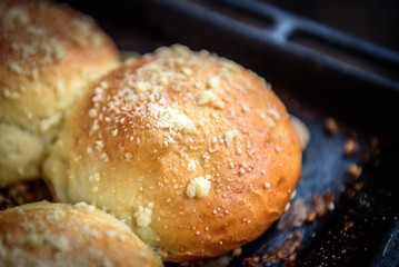 Homemade sweet yeast buns with apple jam on dark wooden background.