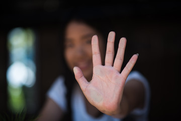 Young woman looking through the glass and touching it with hands