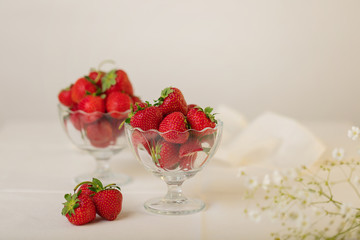 Strawberries in a jelly glass on a white background.