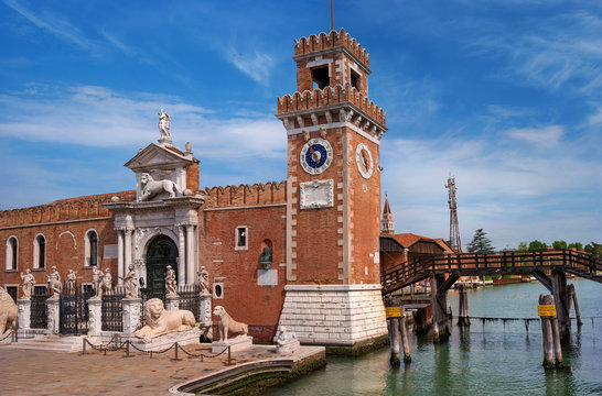 Historic shipyard, Arsenal, gate and the channel. Venice, Italy. The gate is richly decorated with sculptures. bove the gate is a sculpture of a Venetian lion. There's a clock on the tower