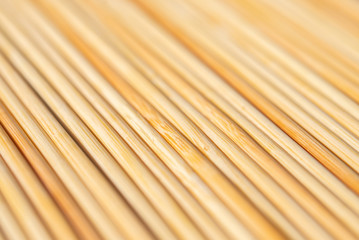 background of parallel round wooden sticks closeup
