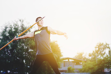 sportsman warming up and practicing javelin throw in yard