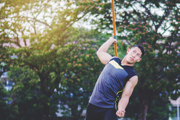 sportsman warming up and practicing javelin throw in yard