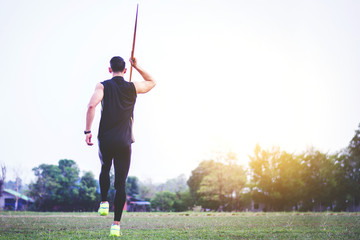 sportsman warming up and practicing javelin throw in yard