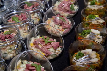 Salads with meat and herring in a glass jar
