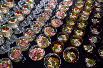 Salads with meat and herring in a glass jar