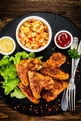 Chicken wings with French fries on wooden background 