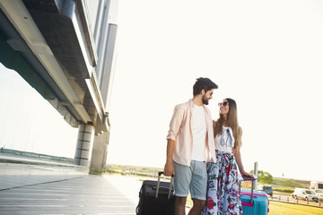 A young couple coming to the airport.