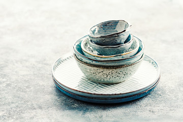 Plates of blue color and bowls on a blue background. Copy space