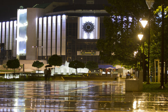 Europe, Bulgaria, Sofia, central park, NDK palace. Night view of National palace of culture building  during heavy rain with reflection on the ground. Bulgarian Presidency of the Council of the EU.