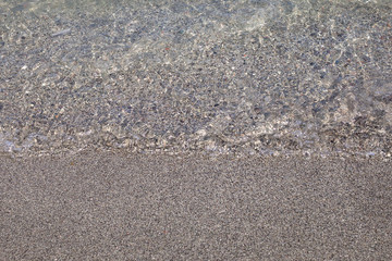 Water and sand close up in Monterosso, Liguria, Italy
