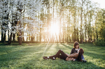 Fototapeta premium The beautiful sisters sitting on the grass