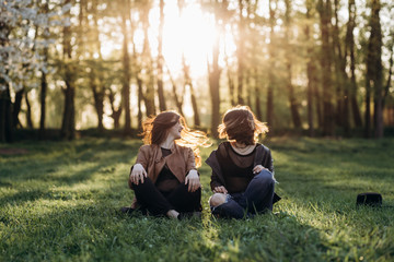 The beautiful sisters sitting on the grass