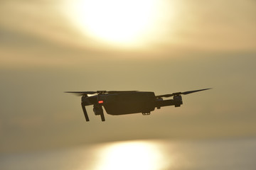 Drone flying in the sunrise sky.