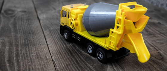 yellow concrete mixer on a wooden background