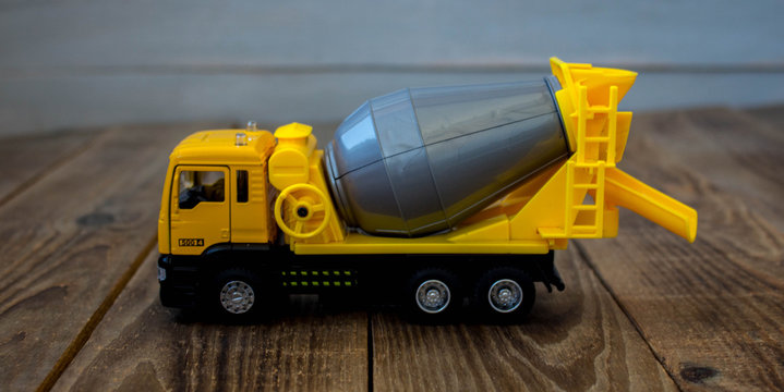 yellow concrete mixer on a wooden background