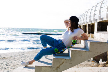 Fototapeta na wymiar Woman with a skateboard on a beach