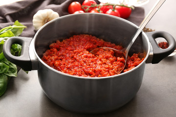 Cooking pot with meat sauce on table