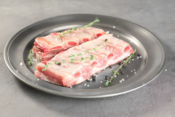 Plate with fresh raw ribs on table