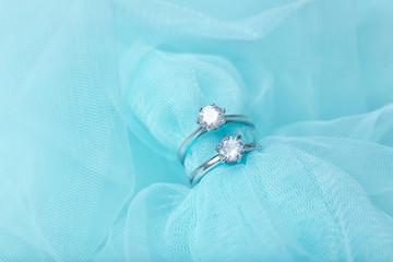 Beautiful engagement rings on color tulle, closeup