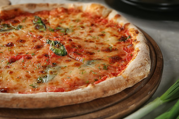 Tasty pizza on board, closeup. Fresh from oven