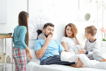 Children waking up their parents in bedroom