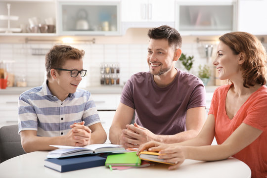 Teenager with parents doing homework at home