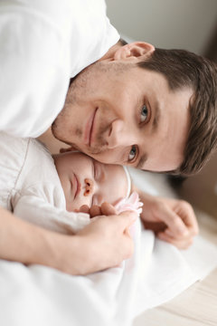 Young father and his baby on bed at home