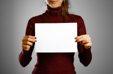 Woman showing blank white flyer paper. Leaflet presentation. Pamphlet hold hands. Girl show clear...
