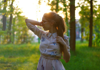 Portrait of a beautiful girl in a dress at sunset. Girl in the Sunny forest