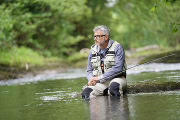 Fisherman fly-fishing in river