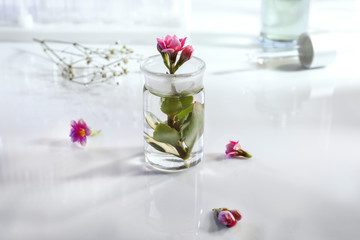 Glass flask with flower on table
