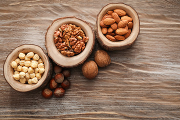 Bowls with various tasty nuts on wooden table