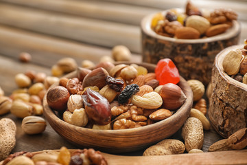Bowls with various tasty nuts on wooden table